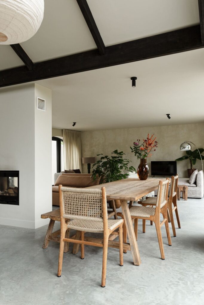 Houten eettafel met houten stoelen en een bankje in Rijnsburg. Gecombineerd met een gevlinderde betonvloer.