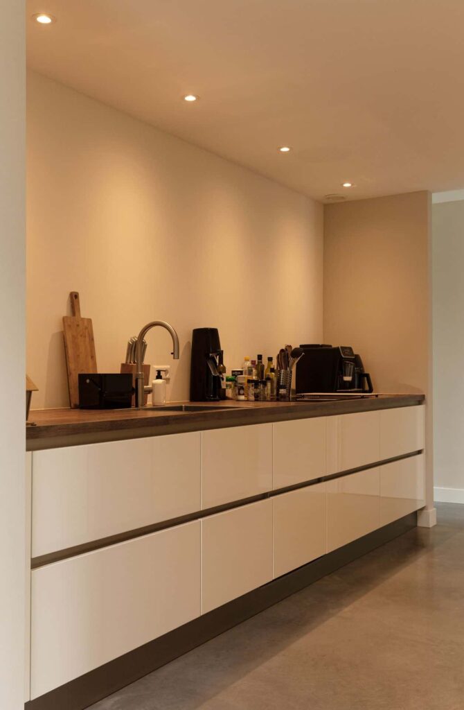 Witte keuken in Woudenberg met hieronder een gevlinderde betonvloer.