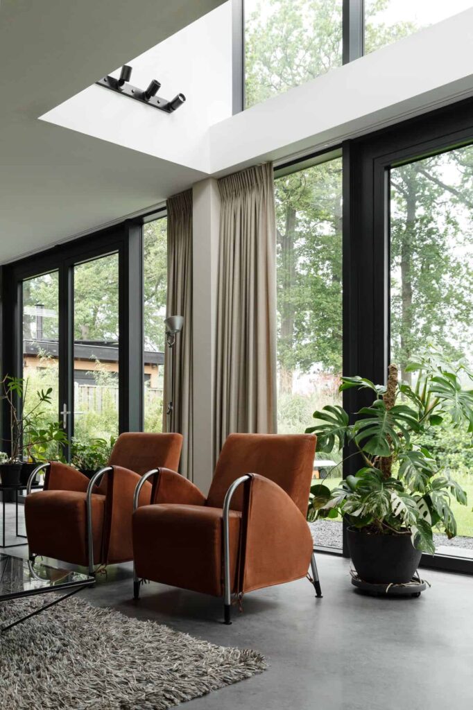 Zithoekje in Woudenberg met 2 oranje stoelen, een plant op de grond en een gevlinderde betonvloer.