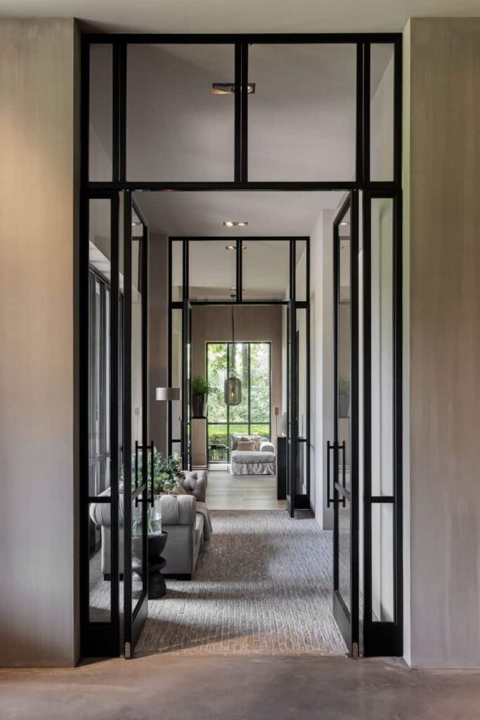 Luxueuze afwerking in een rietgedekte vrijstaande villa in Enschede. Daarbij is een waaltjes vloer gecombineerd met een gevlinderde betonvloer. In de woning zitten veel stalen deuren.