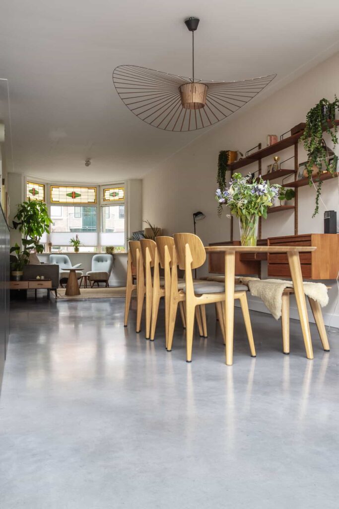 Houten eettafel met houten stoelen op een gevlinderde betonvloer in Haarlem