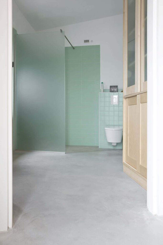 Badkamer met groene muren, betonlook vloer