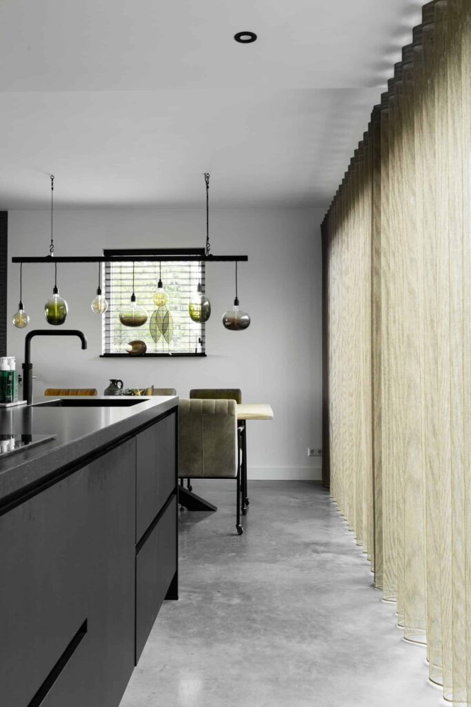 Gevlinderde betonvloer in de keuken van een woning in Hoogblokland. Zwarte keuken