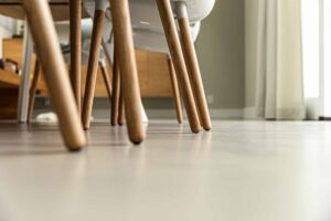 Italiaanse betonlook vloer in Soesterberg met daarop stoelen met houten poten.