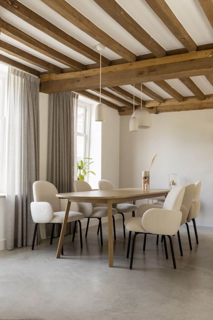 Woning in Kloetinge met een gevlinderde betonvloer van Willem Designvloeren met daarop een houten tafel en teddy stoelen